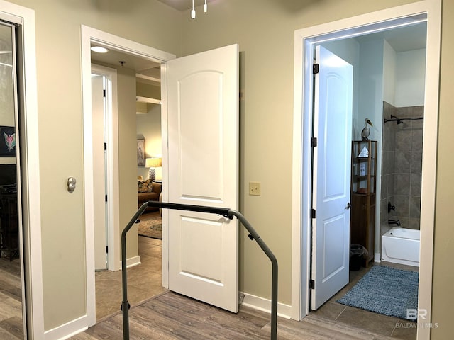 corridor with wood finished floors and baseboards