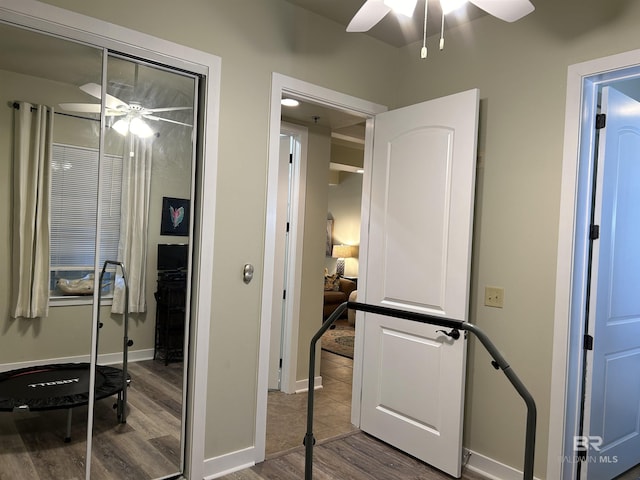 hall featuring baseboards and wood finished floors