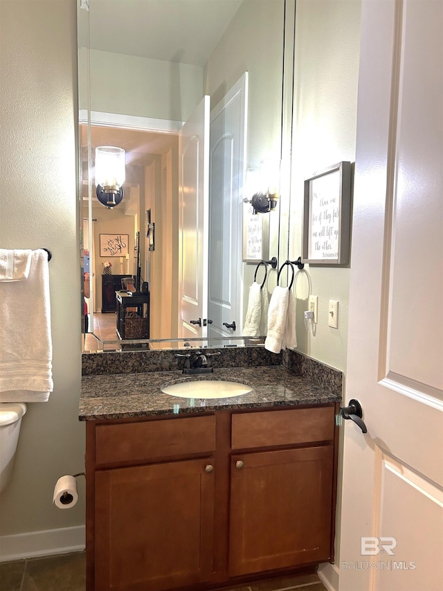 half bathroom featuring vanity and toilet