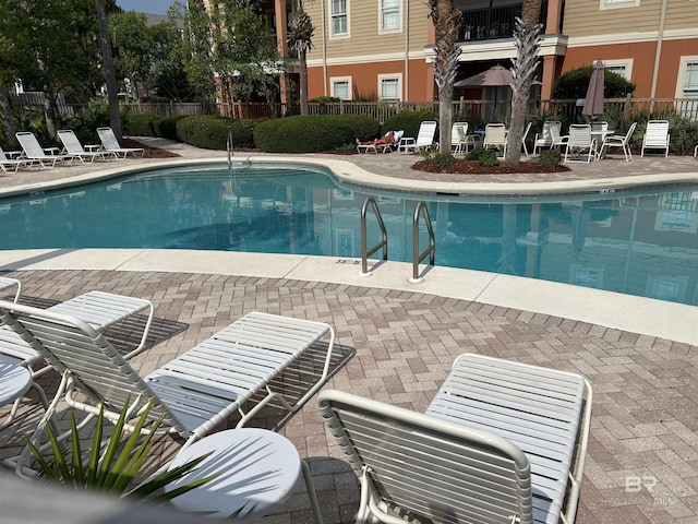 community pool featuring a patio and fence