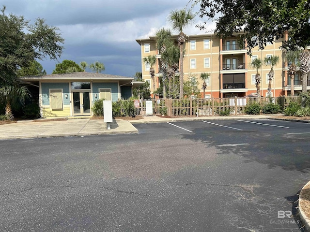 view of property with uncovered parking and fence