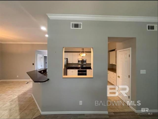 interior space with light tile patterned floors and crown molding