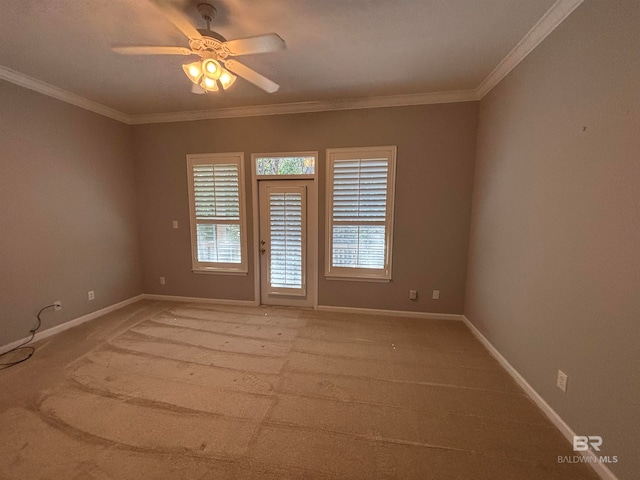 carpeted spare room featuring ceiling fan and crown molding