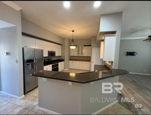 kitchen with decorative light fixtures, white cabinetry, stainless steel appliances, and kitchen peninsula