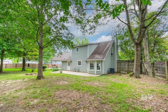 103 Hickory Ct, Daphne, AL 36526 - rear view of house with a chimney, a patio area, a fenced backyard, central AC unit, and roof with shingles