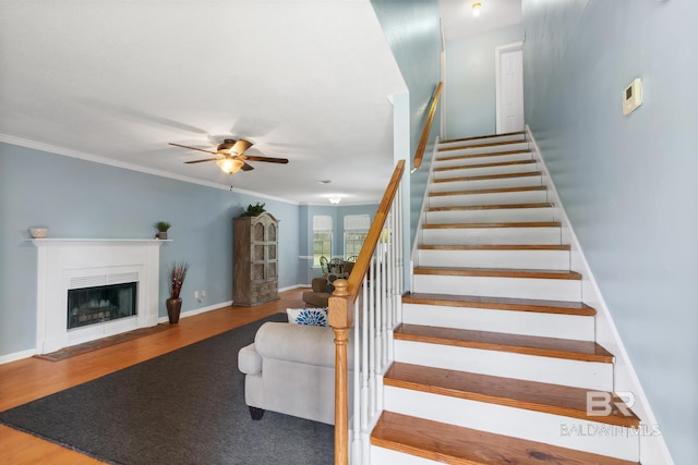 103 Hickory Ct, Daphne, AL 36526 - stairs featuring ceiling fan, wood finished floors, ornamental molding, a fireplace with flush hearth, and baseboards