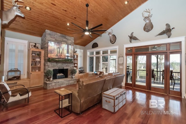 living room featuring wood finished floors, wood ceiling, ceiling fan, and a fireplace