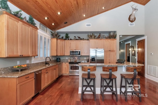 kitchen with a kitchen bar, visible vents, a sink, stainless steel appliances, and wood ceiling