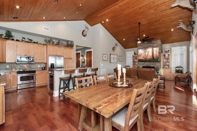 dining room featuring a fireplace, wood ceiling, ceiling fan, and dark wood-style flooring