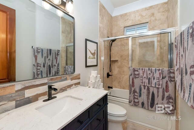 bathroom featuring vanity, toilet, and bath / shower combo with glass door