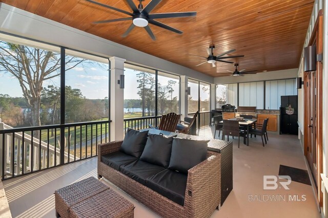 sunroom with ceiling fan and wooden ceiling