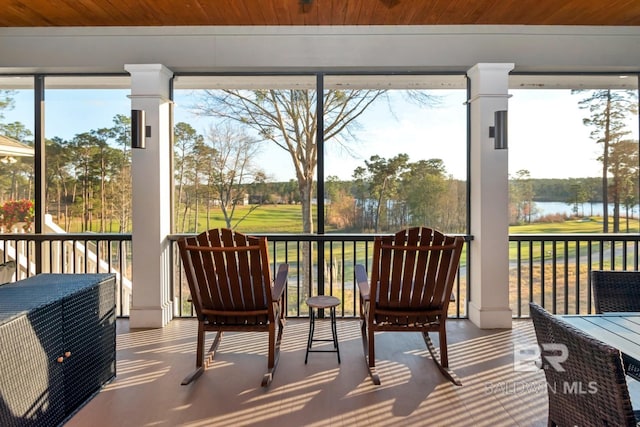 sunroom / solarium with wooden ceiling and a water view