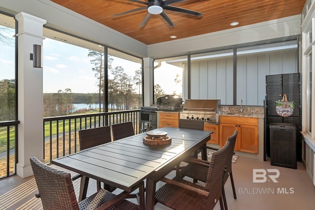sunroom with wood ceiling, a water view, ceiling fan, and a sink