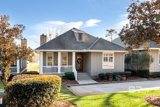 view of front of house with a porch, board and batten siding, and roof with shingles