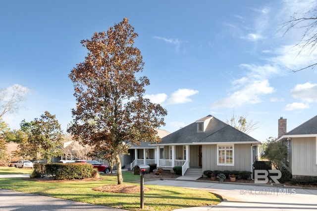 view of front of home featuring board and batten siding, a porch, a front yard, and a shingled roof
