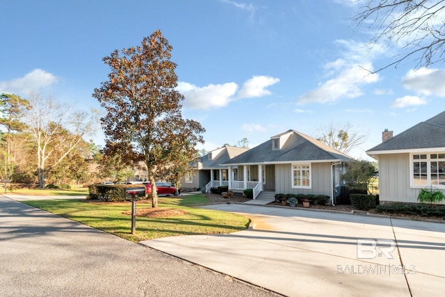 view of front of house featuring a porch, driveway, board and batten siding, and a front yard