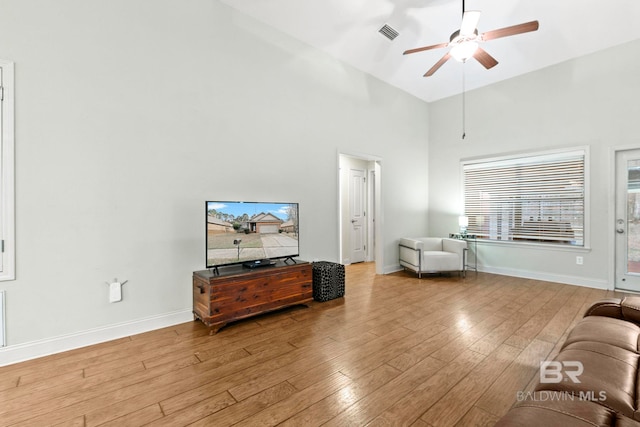 living room with ceiling fan, high vaulted ceiling, and light wood-type flooring