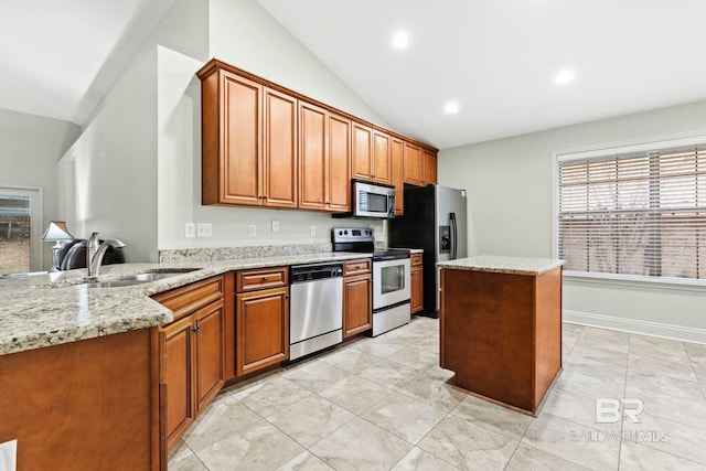 kitchen with vaulted ceiling, sink, light stone counters, kitchen peninsula, and stainless steel appliances