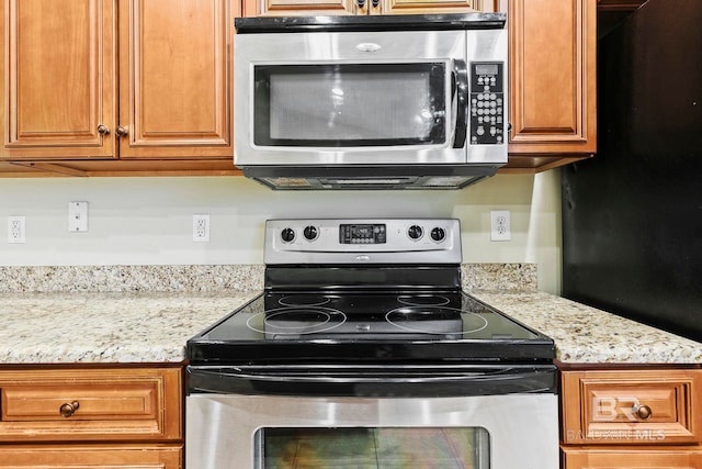 kitchen featuring light stone counters and appliances with stainless steel finishes