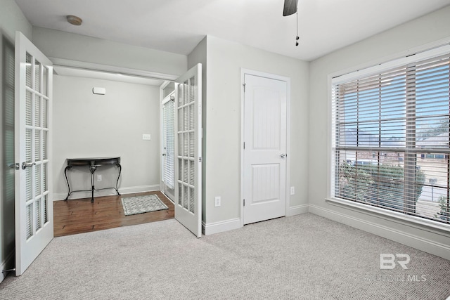 unfurnished bedroom with light colored carpet, ceiling fan, and french doors