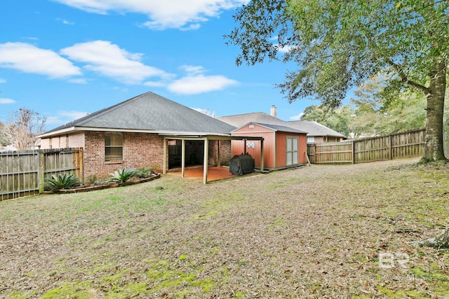 rear view of house with a lawn and a storage unit