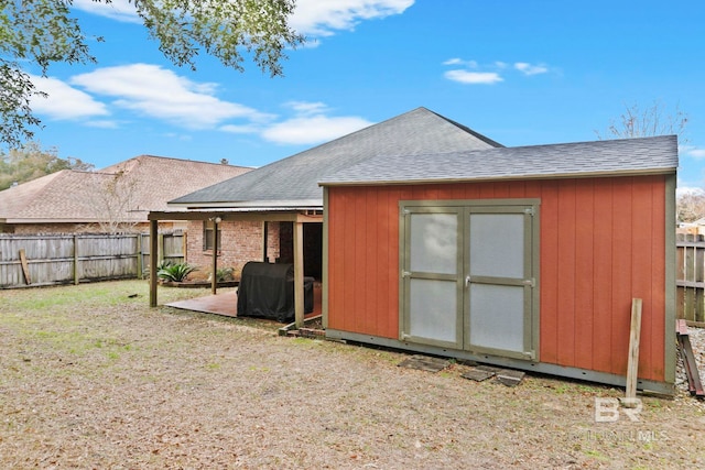 rear view of house featuring a yard, a patio area, and a shed