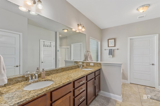 full bath with a sink, visible vents, baseboards, and double vanity