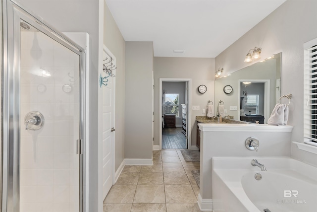 ensuite bathroom with a garden tub, a stall shower, connected bathroom, tile patterned flooring, and baseboards