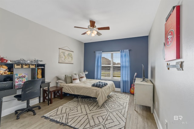 bedroom with ceiling fan, baseboards, and wood finished floors