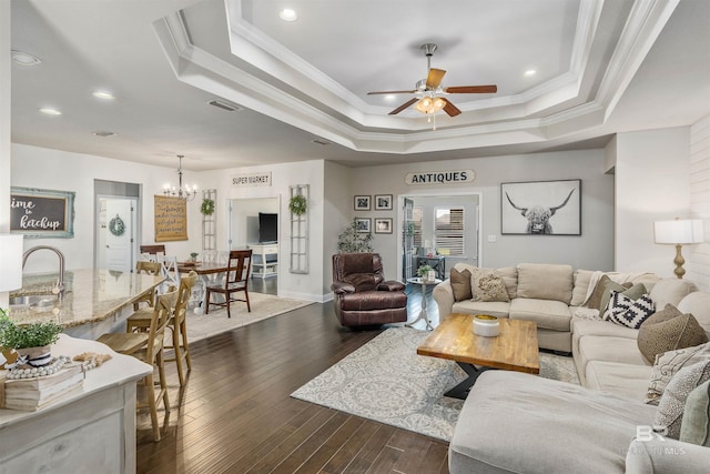 living area featuring crown molding, a raised ceiling, and dark wood-style flooring