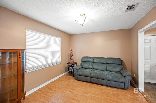 living area with light hardwood / wood-style floors and a textured ceiling