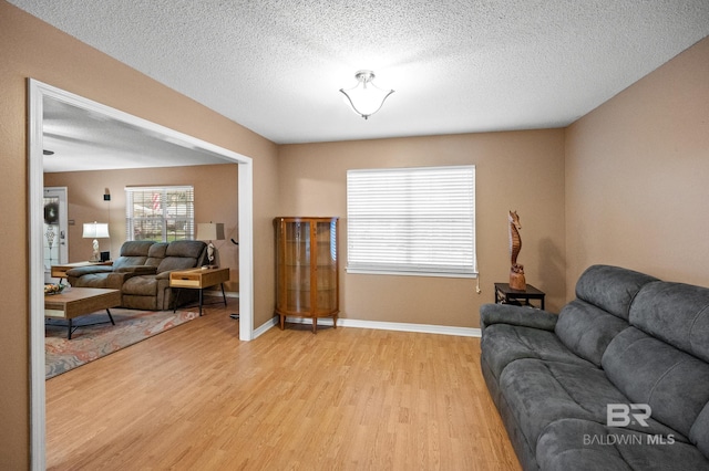 living room featuring a textured ceiling and light wood-type flooring