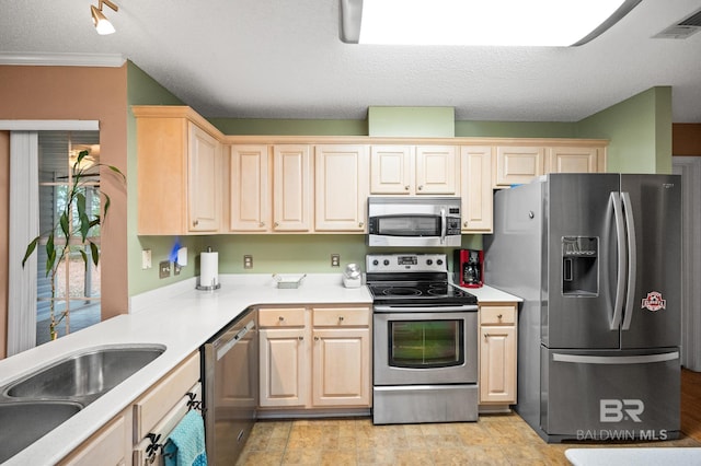 kitchen featuring sink, light brown cabinets, a textured ceiling, and appliances with stainless steel finishes