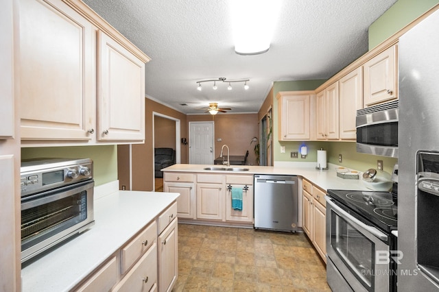 kitchen with sink, a textured ceiling, kitchen peninsula, ceiling fan, and stainless steel appliances