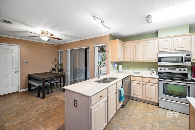 kitchen featuring stainless steel appliances, sink, a textured ceiling, and kitchen peninsula