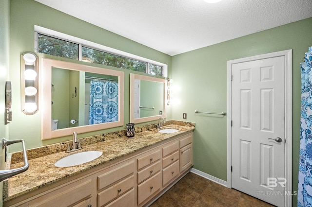 bathroom with vanity, a textured ceiling, and toilet