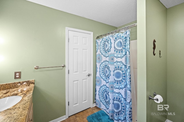 bathroom with vanity, tile patterned floors, a textured ceiling, and walk in shower