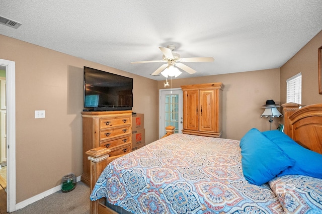 bedroom with ceiling fan, carpet flooring, and a textured ceiling