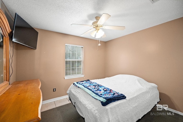 tiled bedroom featuring ceiling fan and a textured ceiling