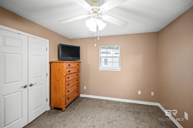 unfurnished bedroom with carpet floors, a textured ceiling, ceiling fan, and a closet