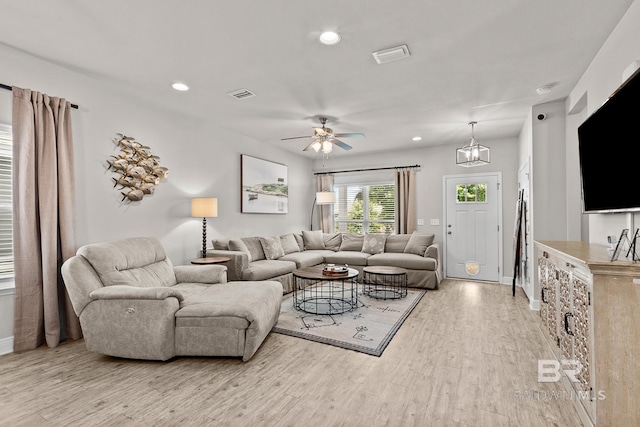 living room featuring light wood-style flooring, visible vents, and recessed lighting
