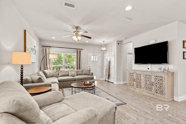 living room featuring light wood-style flooring, visible vents, and recessed lighting