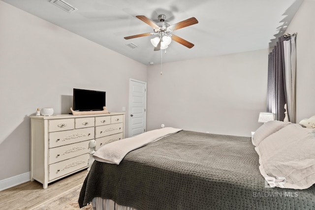 bedroom featuring a ceiling fan, baseboards, visible vents, and light wood finished floors