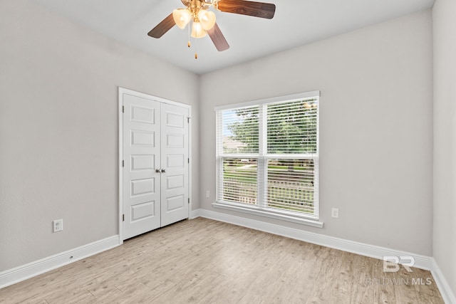 empty room with ceiling fan, light wood-style flooring, and baseboards