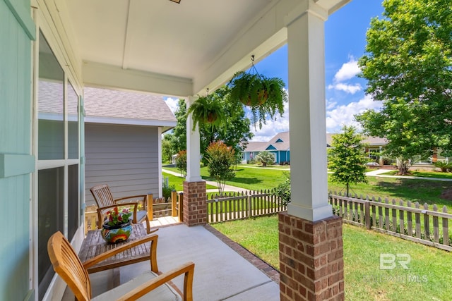 view of patio featuring a porch and fence