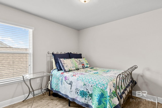 bedroom with baseboards and wood finished floors