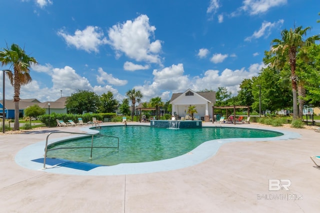 pool with a patio area and fence