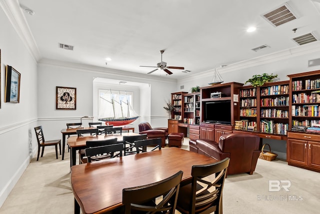 dining room with light carpet, ceiling fan, visible vents, and ornamental molding