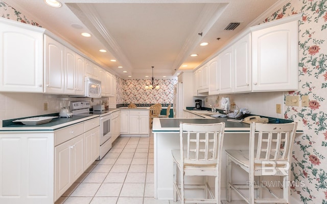 kitchen featuring white appliances, crown molding, a raised ceiling, a breakfast bar area, and tasteful backsplash