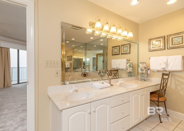 bathroom with vanity with extensive cabinet space, tile floors, double sink, and a textured ceiling